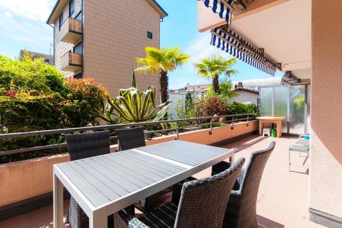 patio con mesa y sillas en el balcón en Agave Apartment by Quokka 360 - flat with large terrace in Lugano, en Viganello