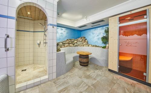een badkamer met een bad, een douche en een douchecabine bij Apart-Hotel Forellenhof in Saalbach Hinterglemm