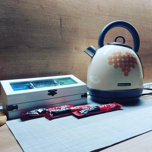 a tea kettle sitting next to a box of chocolates at Apartman Srna Pale in Pale