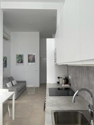 eine Küche mit einem Waschbecken und einem Sofa in einem Zimmer in der Unterkunft MN Homes Fonseca B in Málaga