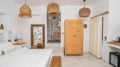 a white room with a bed and a mirror at Salonika Suites in Oludeniz