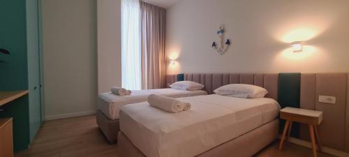 um quarto de hotel com duas camas e uma janela em Salt n Blue Villa Palase em Palasë