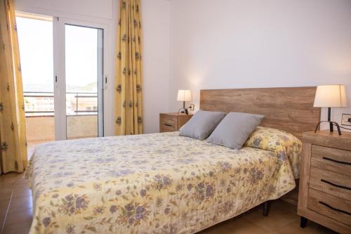 a bedroom with a bed and a large window at RVHotels Apartamentos La Pineda in L'Estartit