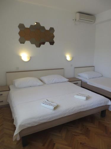a bedroom with two beds with white sheets at Apartments Tonka in Pakoštane