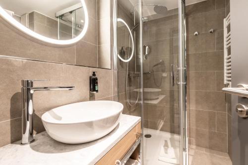 a bathroom with a sink and a glass shower at Premier Inn Saarbrücken City Centre in Saarbrücken