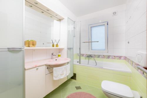 a bathroom with a toilet and a sink and a tub at Villa Marica, Premium residence, Krk in Krk