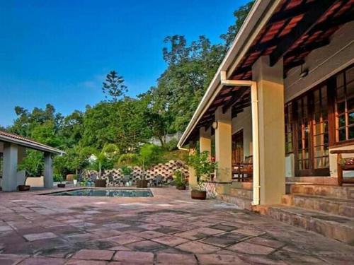 a house with a stone patio and a building at Chez Vincent in Nelspruit