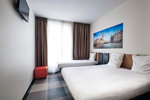 a hotel room with two beds and a tv at easyHotel Brussels City Centre in Brussels