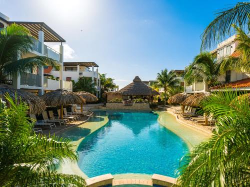 ein Pool mit Palmen und ein Resort in der Unterkunft Resort Bonaire in Kralendijk