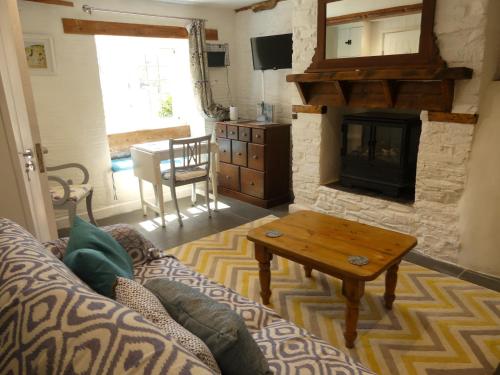 a living room with a couch and a fireplace at Priory Cottage Bodmin in Bodmin