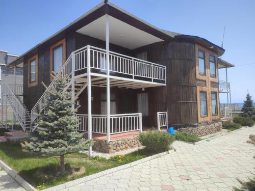 a large wooden house with a tree in front of it at Пансионат Сабрина in Bosteri