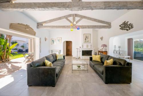 sala de estar con 2 sofás de cuero y chimenea en Villa des Orangers - Villa vue mer avec piscine en Grosseto-Prugna