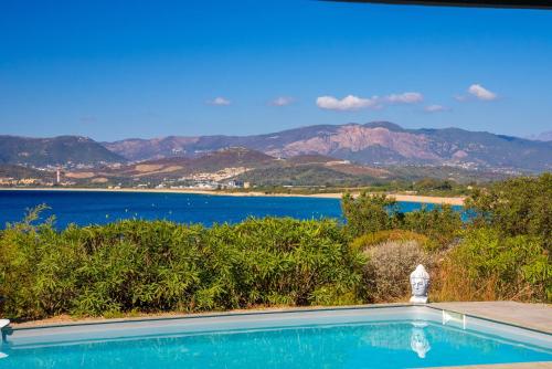 a swimming pool with a view of the water and mountains at Villa des Orangers - Villa vue mer avec piscine in Grosseto-Prugna