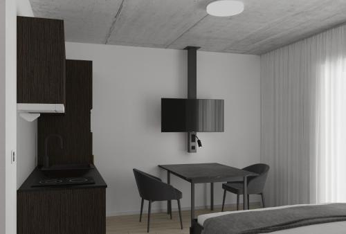 een slaapkamer met een bureau en een bed en een tafel en stoelen bij MOOI Apartments St.Gallen in St. Gallen