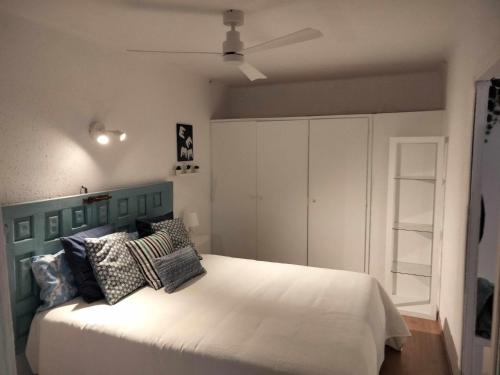 a bedroom with a large white bed with pillows at Cala LLevado Tossa de M. A/C Parking Piscina in Tossa de Mar
