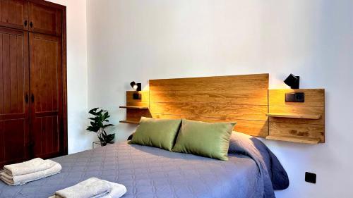 a bedroom with a bed with a wooden headboard at Chalet El Parral - Piscina y Sala de Cine in Málaga