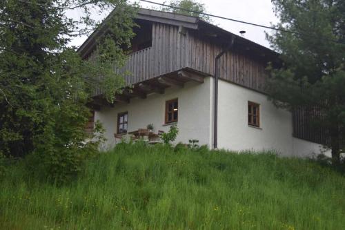a white house with a wooden roof at Birken Chalet in Falkenfels