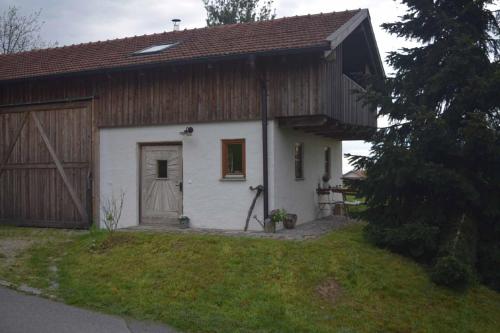 a small white house with a wooden barn at Birken Chalet in Falkenfels