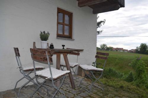 une table et deux chaises devant une maison dans l'établissement Birken Chalet, à Falkenfels