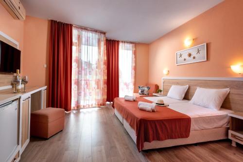 ラブダにあるCopacabana Hotelのベッドと大きな窓が備わるホテルルームです。