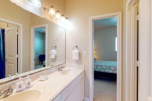 baño con 2 lavabos y espejo grande en Chic 3 BR Home With Pool and Hot Tub en Port Aransas