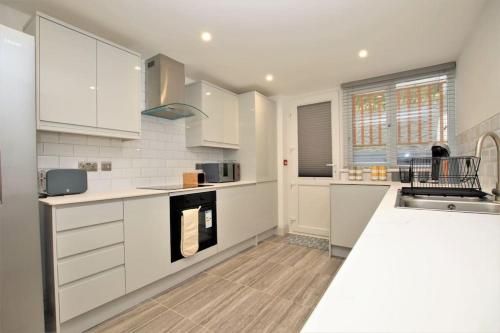 a kitchen with white cabinets and a counter top at St James Apartment in Ilfracombe