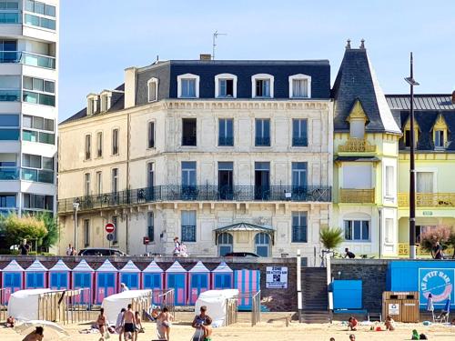 un grupo de personas en una playa frente a un edificio en Ma Location Sablaise - Appart' Grande Plage, en Les Sables-dʼOlonne