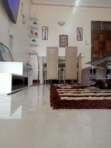uma sala de estar com uma mesa e cadeiras e um tapete em 1 bedroom furnished em Mombasa