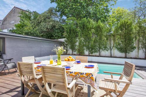 un patio avec une table et des chaises et une piscine dans l'établissement Villa Miarritze - Welkeys, à Biarritz
