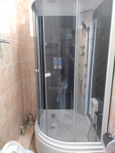 a bathroom with a shower and a toilet in it at Пансионат Сабрина in Bosteri