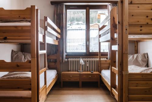 a dorm room with bunk beds and a window at Aktiv Hotel & Spa Hannigalp in Grächen