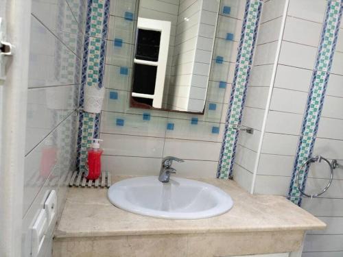 bagno con lavandino e specchio di Élégant appartement 3 chambres a Rabat