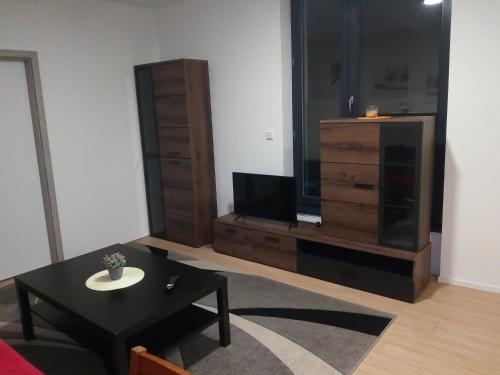 a living room with a tv and a coffee table at Apartmán Štefánikova in Zlín