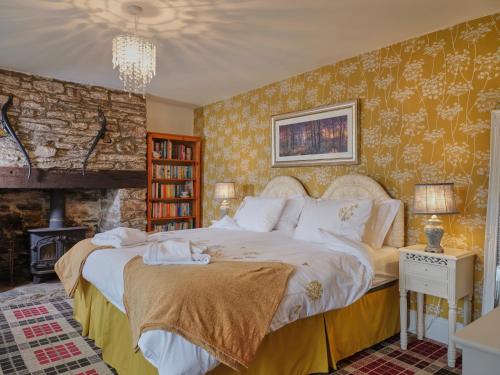West Anstey的住宿－Deer's Leap Retreat，一间卧室设有一张大床和一个壁炉