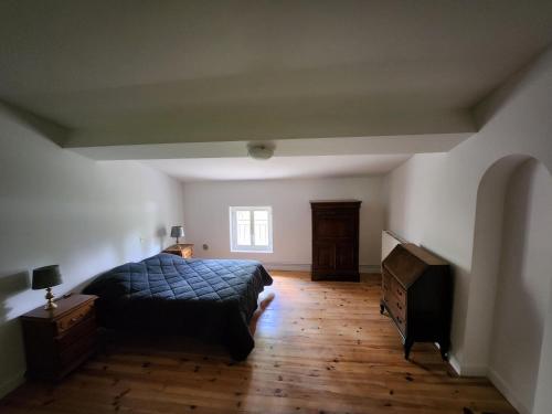 - une chambre avec un lit, une commode et une télévision dans l'établissement DOMAINE DE POULHARIES -Blanquette, à Carcassonne