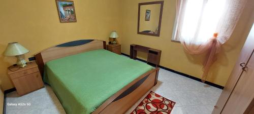 um quarto com uma cama verde e uma janela em Villa Pisciotto em Licata