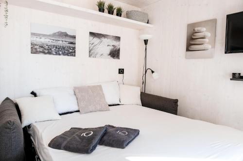 1 dormitorio con cama blanca y sofá en Buqez resort Drage, villa Vita 50, en Pakoštane