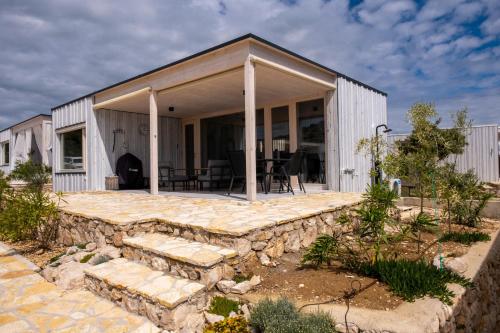 ein Haus mit einer Steinwand und einer Terrasse in der Unterkunft Buqez resort Drage, villa Vita 50 in Pakoštane
