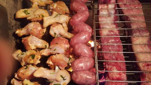 a bunch of meats and sausage on a grill at Apartamento Aconchegante e Confortável com ou sem Ar Condicionado in Porto Alegre