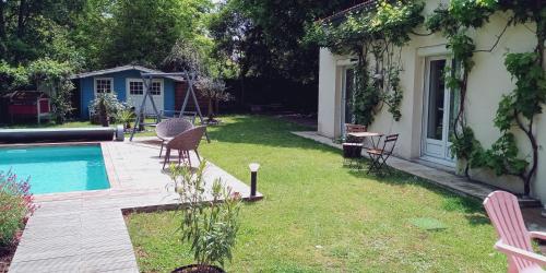 une cour avec une piscine et des chaises et une maison dans l'établissement Mérig'home Chambre BD climatisée dans maison avec piscine au calme en ville, SdB & toilettes privés, à Angoulême