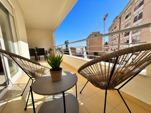 a balcony with two chairs and a table with a plant at Sesimbra Oásis São João in Sesimbra