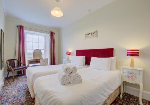 um quarto de hotel com duas camas com toalhas em Carnevas Farmhouse em Saint Merryn