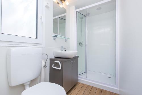 e bagno con servizi igienici, lavandino e doccia. di KNAUS Campingpark Dorum a Dorum-Neufeld