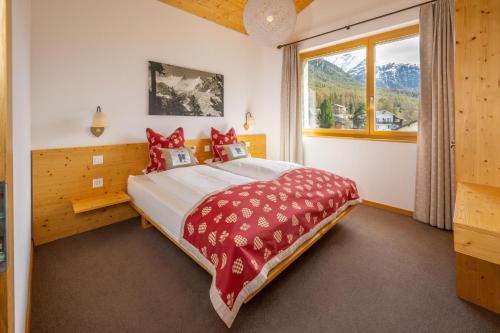 a bedroom with a large bed and a window at Aktiv Hotel & Spa Hannigalp in Grächen