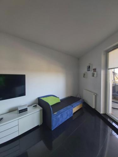 レダにあるApartament "DESTINATION" przy AQUAPARKuのベッド1台とテレビが備わる小さな客室です。