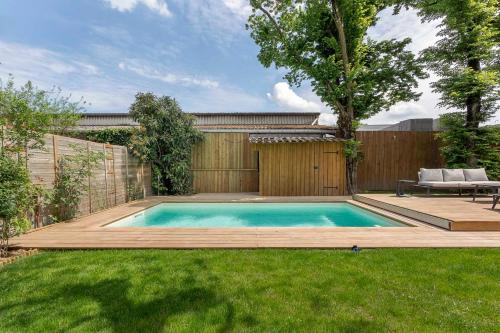 uma piscina num quintal com uma cerca de madeira em Familial villa with pool - Tassin-la-Demi-Lune - Welkeys em Tassin-la-Demi-Lune