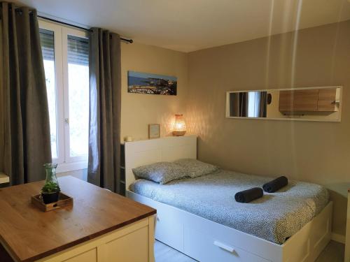 une petite chambre avec un lit et une table dans l'établissement Baiona Sainte Cath 3-HIRU cœur de Saint Esprit, à Bayonne