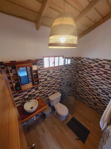 a bathroom with a sink and a toilet and a chandelier at Villas Montelindo in Constanza