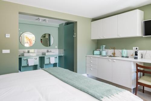 1 dormitorio con 1 cama, 2 lavabos y espejo en Villa Camélia Boutique House, en Camacha