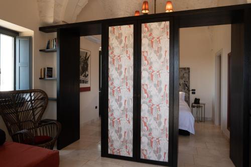 a room with a sliding glass door with flowers on it at Masseria Santo Scalone in Ostuni